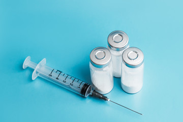 medical ampoules and syringe isolated on blue background 