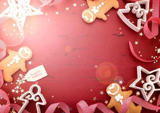 Christmas Happy Holidays Background With White Wood Ornaments And Gingerbread Men Cookies On Red Wood Table, With Added Filters And Lens Flare..