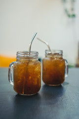 Iced tea in glass mason jars on wooden table, selective focus