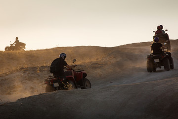 People enjoying driving atv on sunset in Valleys of Cappadocia with lot of dusts in background. © danmir12