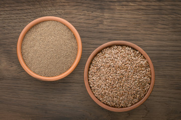Flax seeds and ground seed in earthenware bowls