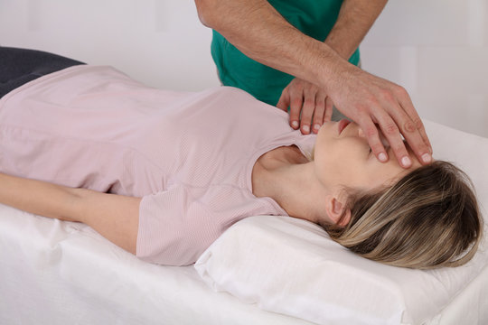 Alternative medicine and holistic health care. Woman having reiki healing treatment. Osteopathy, Physiotherapy concept