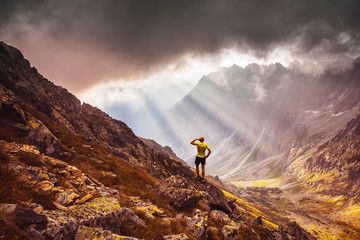 Man standing over the valley in mountains. Beautiful light, inspirational photo
