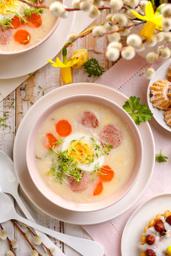White borscht, polish Easter soup with the addition of white sausage and a hard boiled egg in a ceramic bowl, top view. Traditional Easter dish in Poland