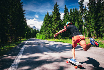 Young man on longboard on the road in nature. © kovop58