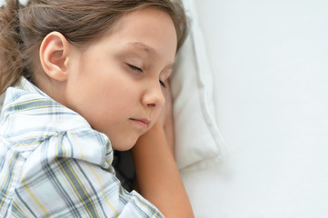 Portrait of tired little girl sleeping in bed