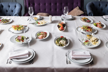 Served for banquet restaurant table with dishes, snack, cutlery, wine and water glasses, european food, selective focus
