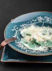 Ravioli with spinach and basil, parmesan cheese on plate over black stone background. Clean eating, vegetarian food concept