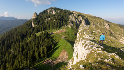 Girl hiking through the Buila Vanturarita national park in Romania on a sunny summer day