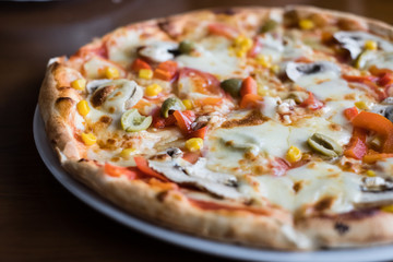 Close up Italian pizza with olives, tomatoes and che