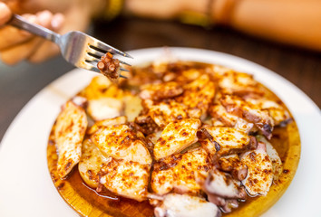 Happy woman eating delicious grilled octopus, spanish and mediterranean seafood cuisine concept
