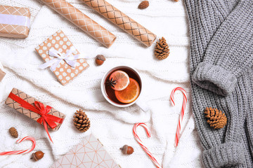 Fototapeta na wymiar Flat lay composition with cup of hot winter drink on warm knitted plaid. Cozy season