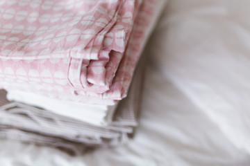 a stack of clean and ironed linen is on the bed