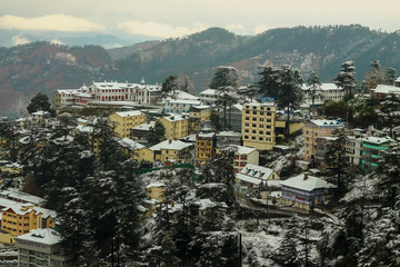 Aerial view of a snowcapped city just next to the mountains