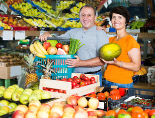 Fototapeta premium Couple standing with basket of purchases