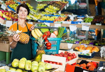 Obraz premium Portrait of smiling female seller is standing with basket