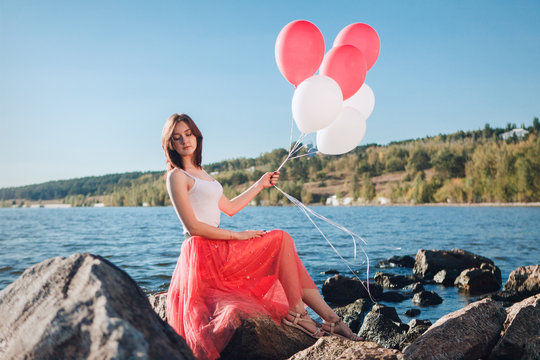Pretty girl with many colored balloons in hand