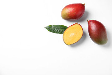 Tropical cut and whole mango with green leaf isolated on white, flat lay. Space for text