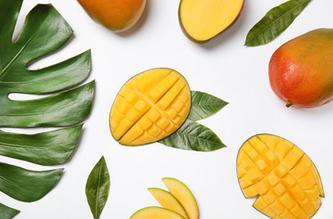 Fresh mango and green leaves on white background, flat lay