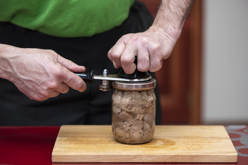 Preparation of homemade pork stew, machine for canning food, process close up