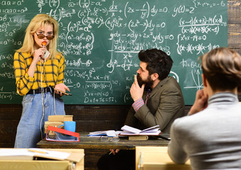 Tutor will have to re-evaluate the students objectives. Trained professional who teaches group of students. Students sitting together at table.