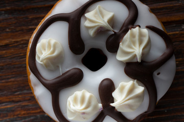 Fresh donut served on the old wooden table with a clearly visible texture