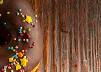 Fresh donut served on the old wooden table with a clearly visible texture