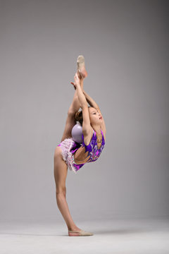 Little girl gymnast, performs various gymnastic and fitness exercises. The concept of childhood and sport