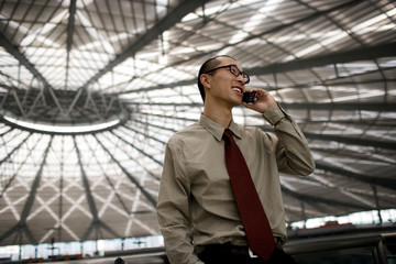 Young adult businessman talking on a cellphone.