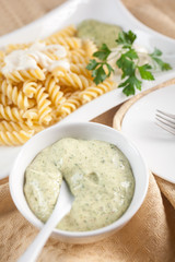 Pasta in white plate, parsley, bowl with mayonnaise sauce