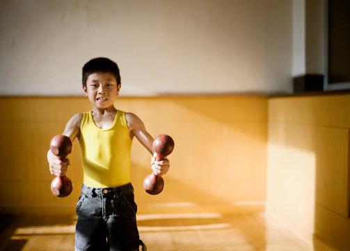 Portrait of a boy lifting weights.