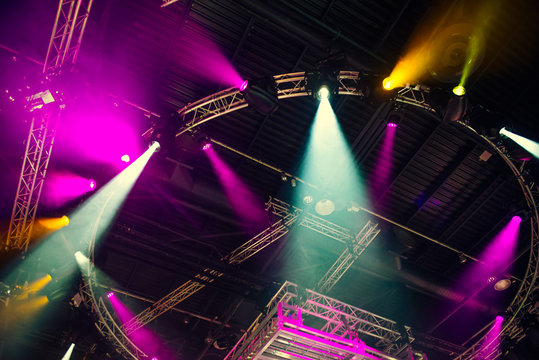 Stage lights on concert. Lighting equipment with multi-colored beams. Bottom view. Selective focus. Copy space.