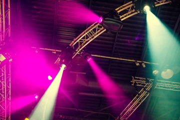 Stage lights on concert. Lighting equipment with multi-colored beams. Bottom view. Selective focus. Copy space.