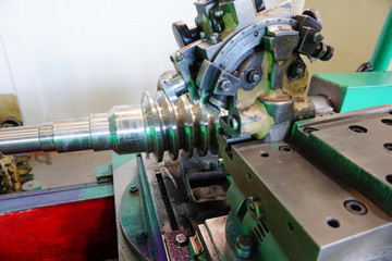 Grinding of the worm shaft on the backing machine. Industrial industry manufacturing gear shafts.