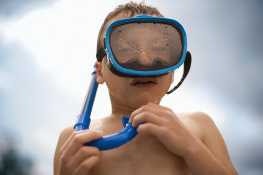 Portrait of a young boy wearing a swimming mask and snorkel.
