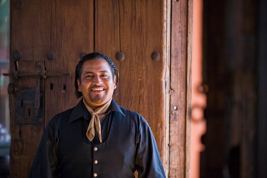 Portrait of a smiling mid-adult man dressed in traditional clothing.