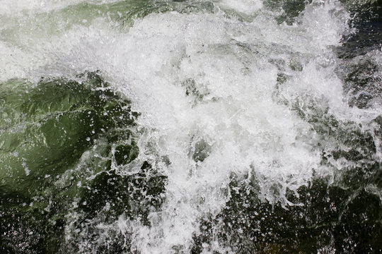 Rushing water of a river through rugged terrain.