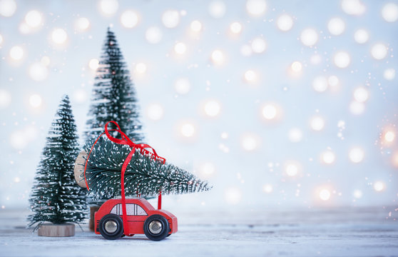 Winter Christmas background Miniature red car with fir tree. Holiday greeting card.