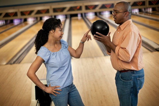Playful mid adult woman teasing her partner at a bowling alley.