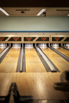 Empty bowling lanes with pins lined up.
