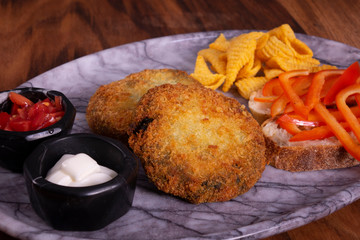 Crispy vegetable meatballs on a plate. Yummy patties made of potatoes, green peas, carrot and green beans and garnished with fresh green onion. Veggie lunch or dinner idea