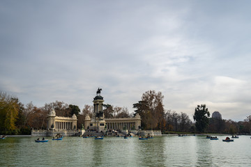 Fototapeta na wymiar Peaceful lake and Monument to King Alfonso XII in Parque del Buen Retiro. Buen Retiro Park - one of largest parks of Madrid City. Spain.