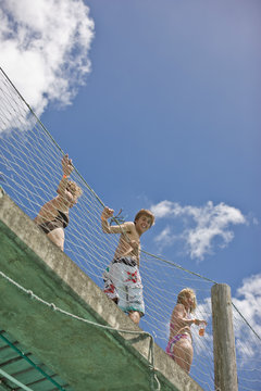 Portrait of three teenagers looking down from a wharf.