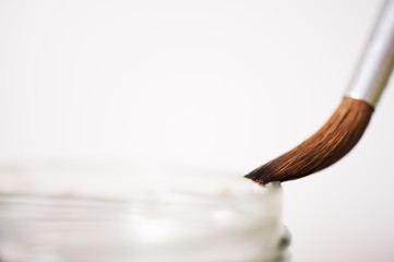 Close-up of paintbrush and glass. Selective focus and shallow depth of field.