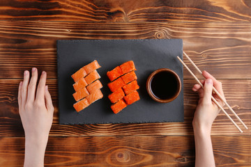 japanese roll flat lay with hand. set of california nad philodelphia rolls on slate plate and...