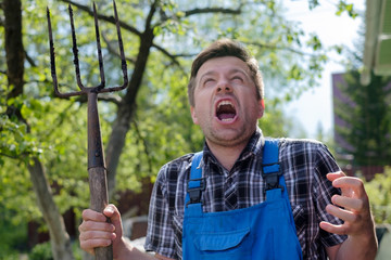 European man with pitchfork is angry, losing his mind.