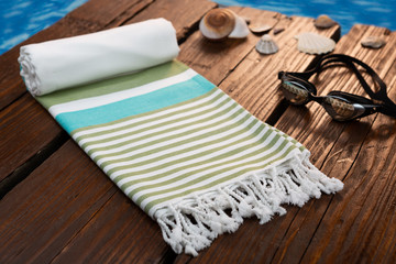 Handwoven hammam Turkish cotton towel on wooden background