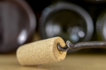 A corkscrew for uncorking wine and old corks on a wooden table. Old wine accessories.