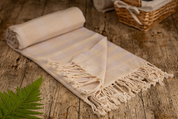 Fototapeta na wymiar Handwoven hammam Turkish cotton towel on wooden background
