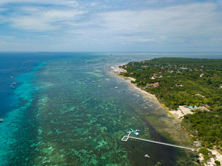 Aerial view of Alona beach at Bohol island. Beautiful tropical island landscape with traditional boats, sand beach and palm trees. Philippines.